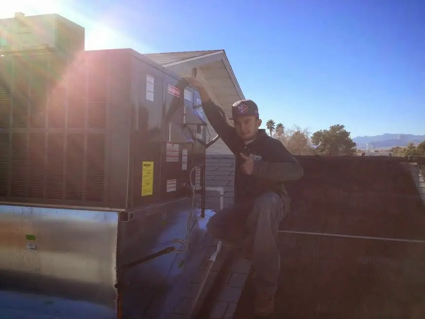 HVAC technician performing Boiler Repair on a rooftop unit in Lockhart